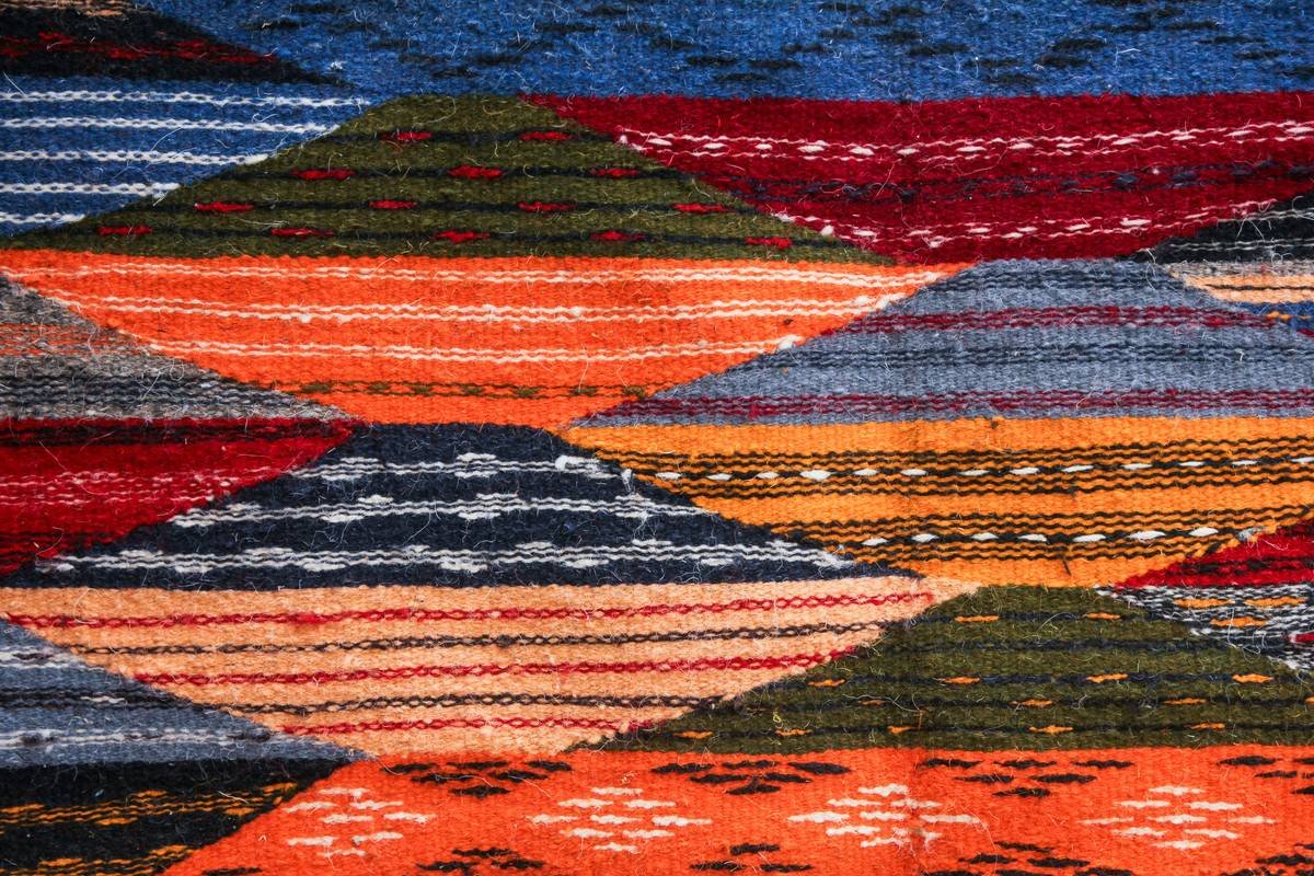 Close-up texture of multi colored berber carpet showing looped fibers and speckled hues